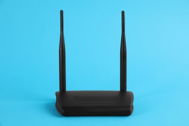 Photo of Modern Wi-Fi router on light blue background