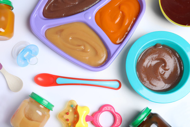 Flat lay composition with healthy baby food and accessories on white background