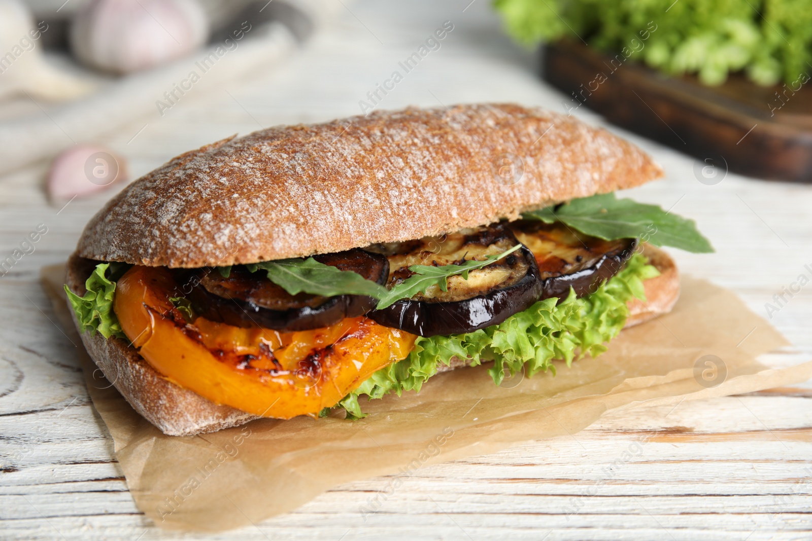 Photo of Delicious eggplant sandwich on white wooden table