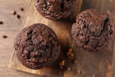 Delicious chocolate muffins on wooden table, top view