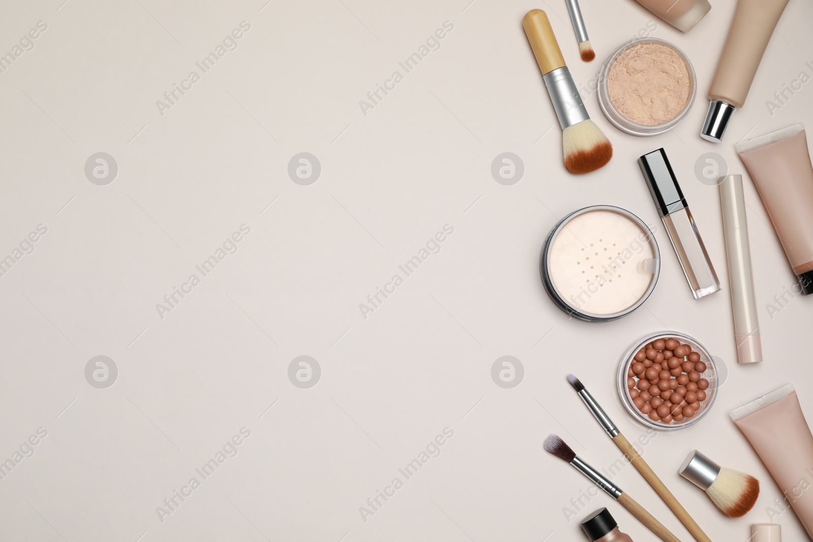 Photo of Face powders and other makeup products on beige background, flat lay. Space for text