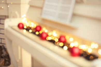 Photo of Blurred view of white piano with festive decor indoors, closeup. Christmas music