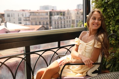 Beautiful young woman on balcony. Space for text