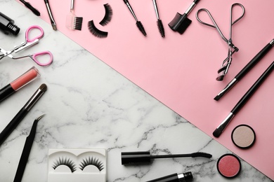 Photo of Flat lay composition with artificial eyelashes, cosmetic and space for text on table