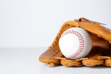 Photo of Catcher's mitt and baseball ball on white background, space for text. Sports game
