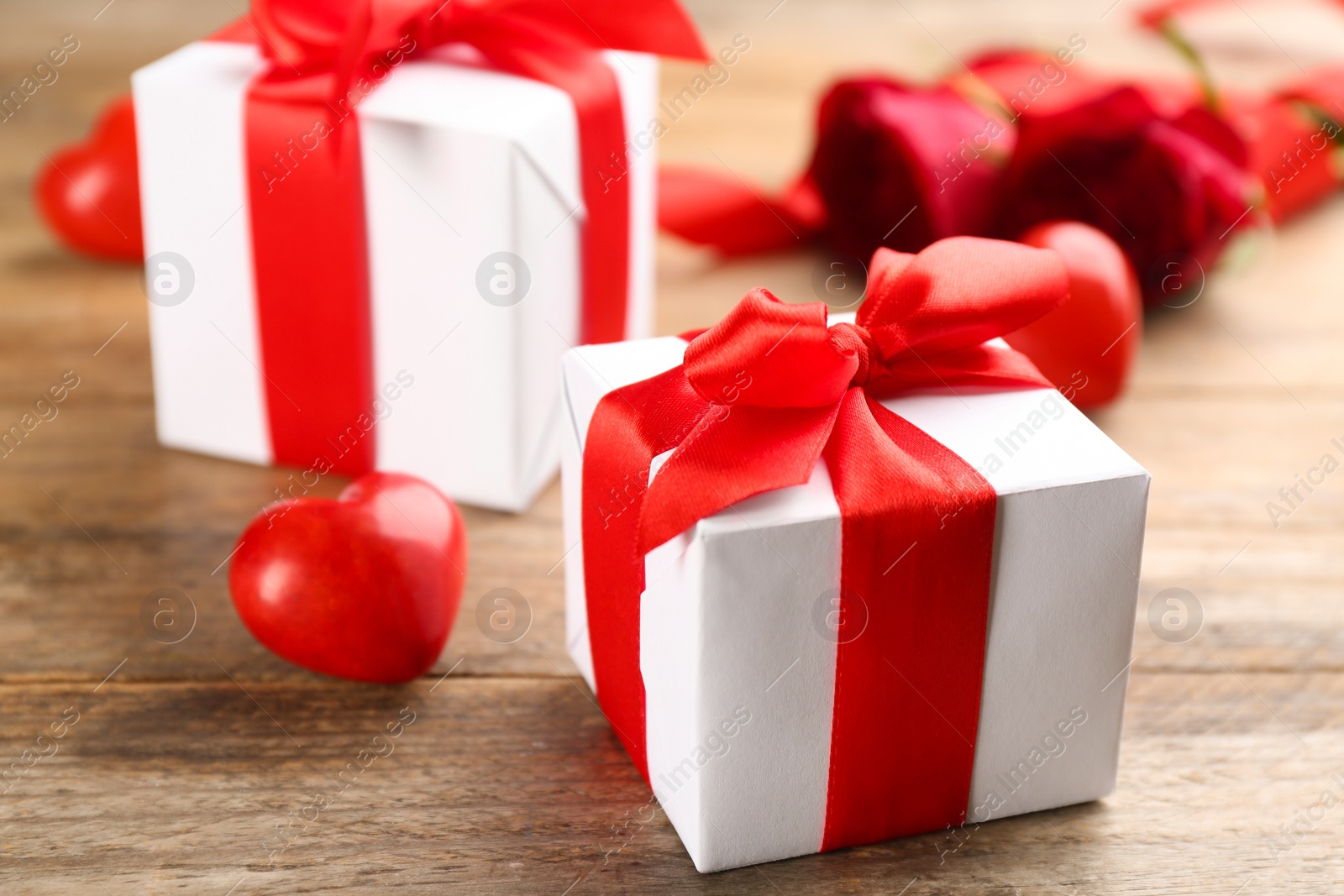 Photo of Beautiful gift boxes on wooden table, closeup. Valentine's Day celebration