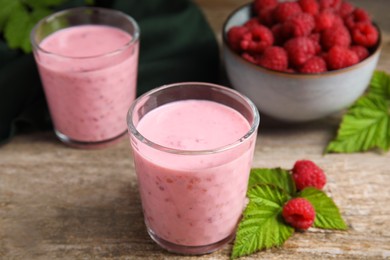 Tasty raspberry smoothie and fresh berries on wooden table