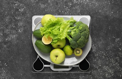 Photo of Healthy diet. Scale and fresh products on black textured table, top view