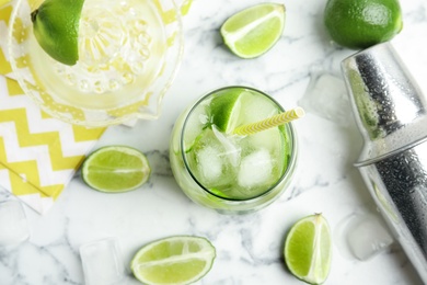 Photo of Delicious mojito and ingredients on white marble table, flat lay