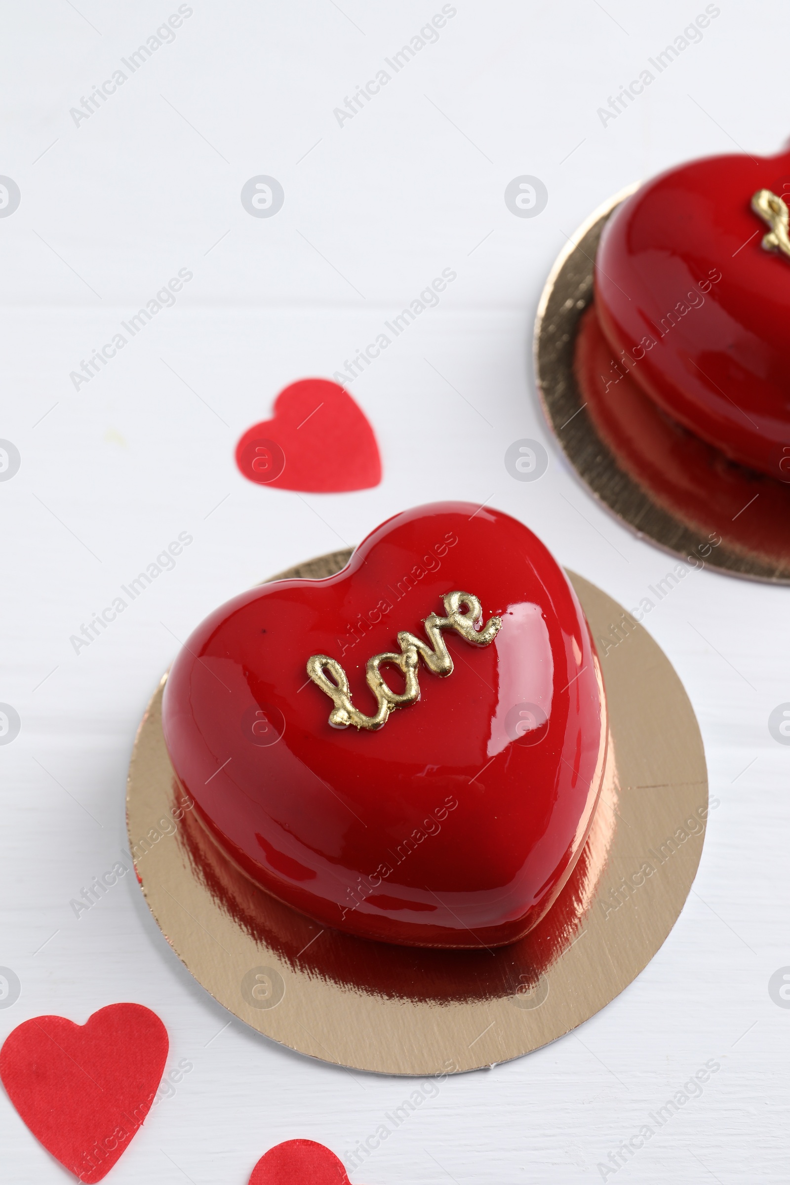 Photo of St. Valentine's Day. Delicious heart shaped cakes and confetti on white wooden table, closeup