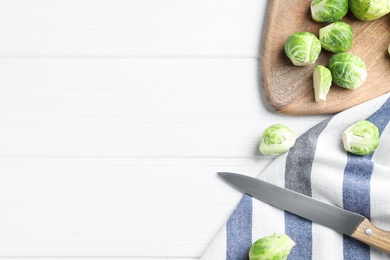 Photo of Fresh Brussels sprouts on white wooden table, flat lay. Space for text