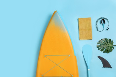 Photo of Flat lay composition with SUP board on light blue background. Water sport