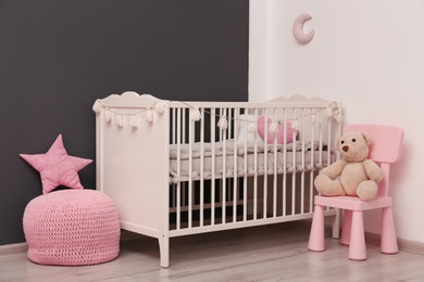 Photo of Stylish baby room interior with comfortable crib