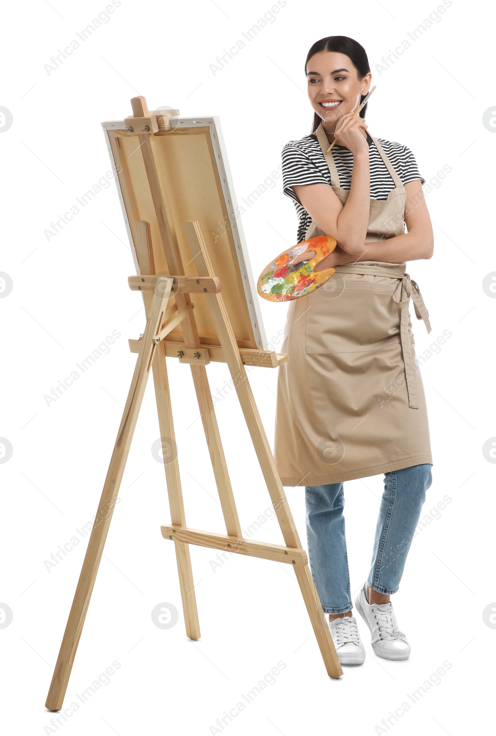 Photo of Young woman with drawing tools near easel on white background