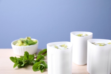 Photo of Kiwi yogurt on table against color background, space for text. Multi cooker recipe