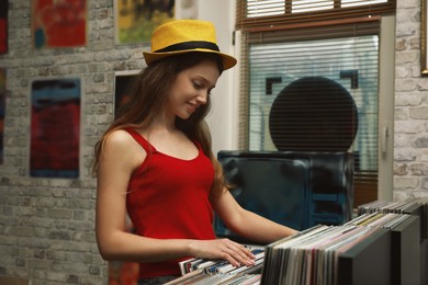 Image of Young woman choosing vinyl records in store