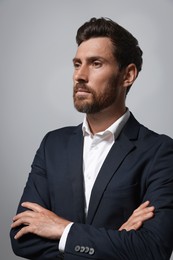 Handsome bearded man in suit on light grey background