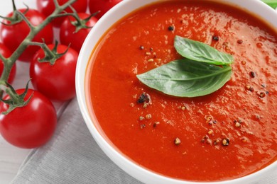 Photo of Delicious tomato cream soup in bowl on table, closeup