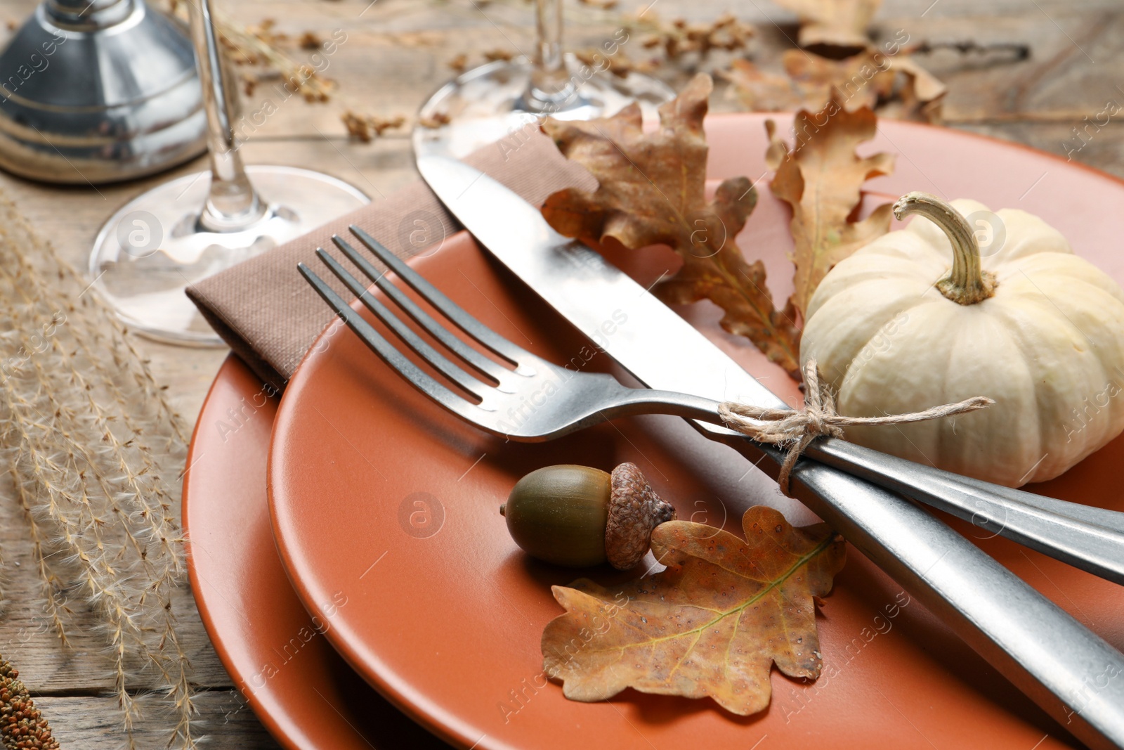 Photo of Festive table setting with autumn decor on wooden desk, closeup