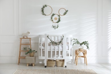 Photo of Stylish baby room decorated with eucalyptus branches