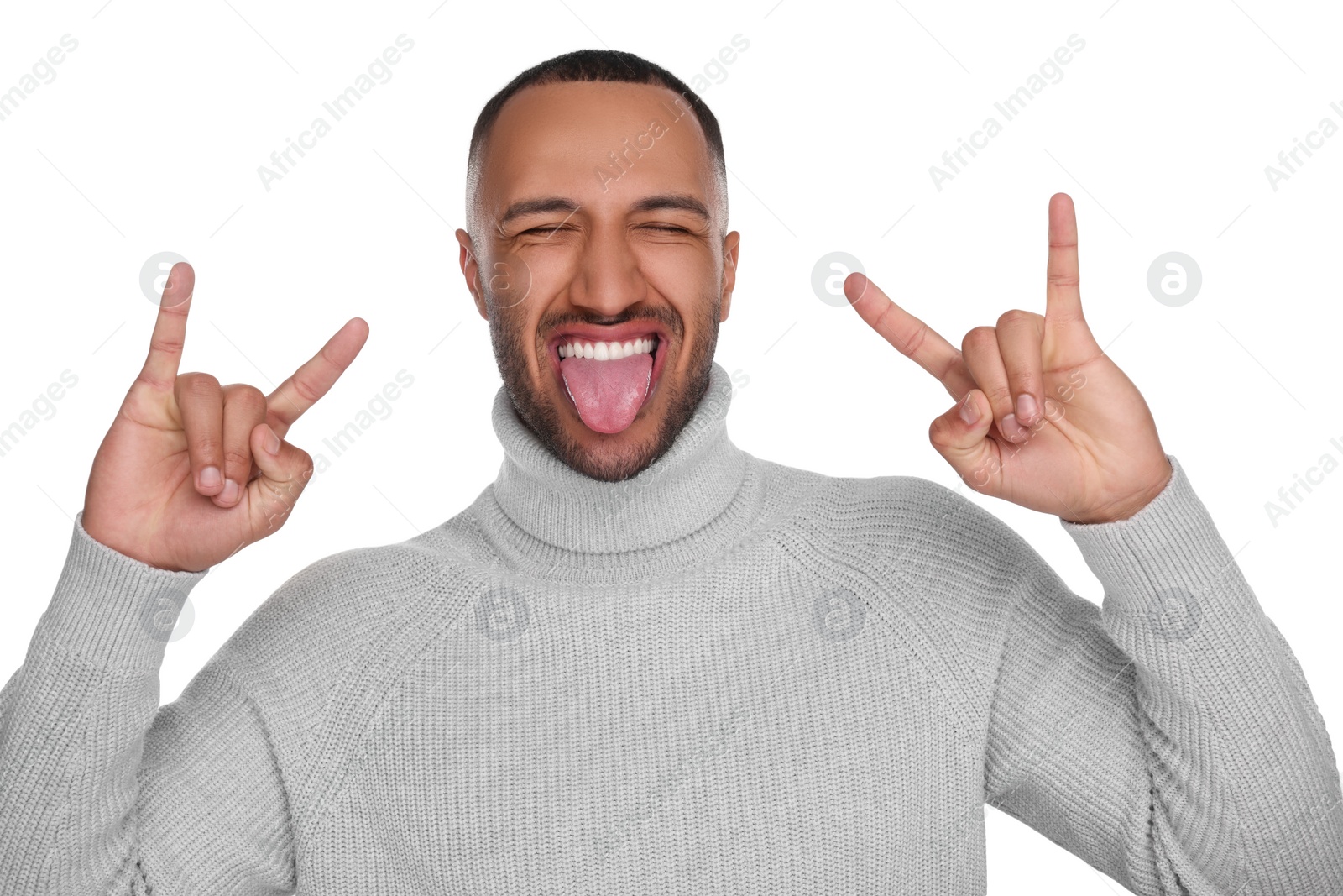 Photo of Happy young man showing his tongue and rock gesture on white background