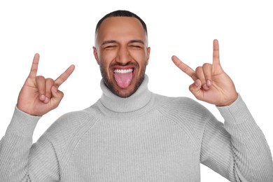 Photo of Happy young man showing his tongue and rock gesture on white background