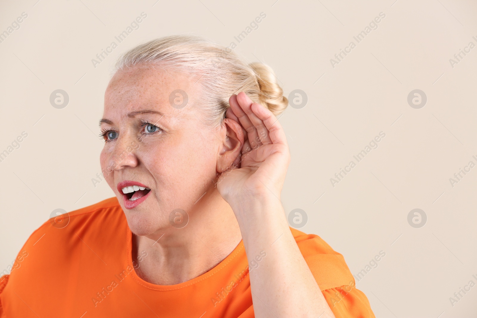 Photo of Mature woman with hearing problem on light background