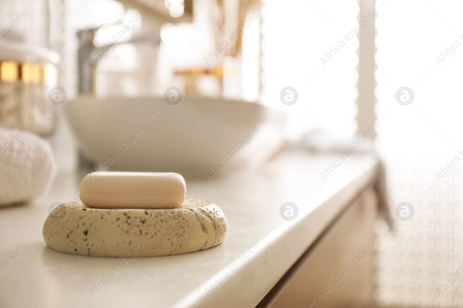 Photo of Bar of soap on countertop in modern bathroom interior