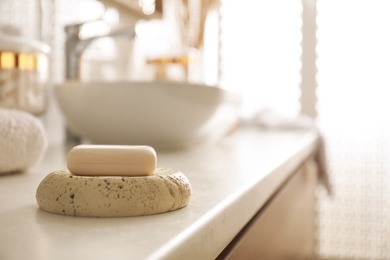 Photo of Bar of soap on countertop in modern bathroom interior