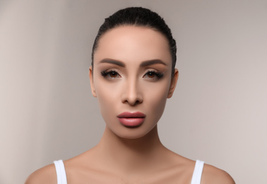 Photo of Beautiful woman with pink lipstick on light background