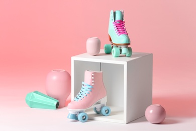 Photo of Composition with vintage roller skates and storage cube on color background