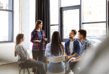 Photo of Psychotherapist working with patients in group therapy session indoors