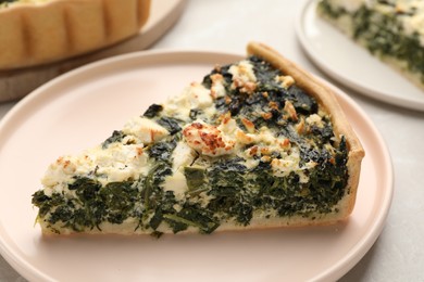 Photo of Piece of delicious homemade spinach quiche on table, closeup