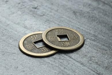 Photo of Chinese coins on grey textured table, closeup