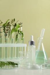 Natural ingredients for cosmetic products and laboratory glassware on white table