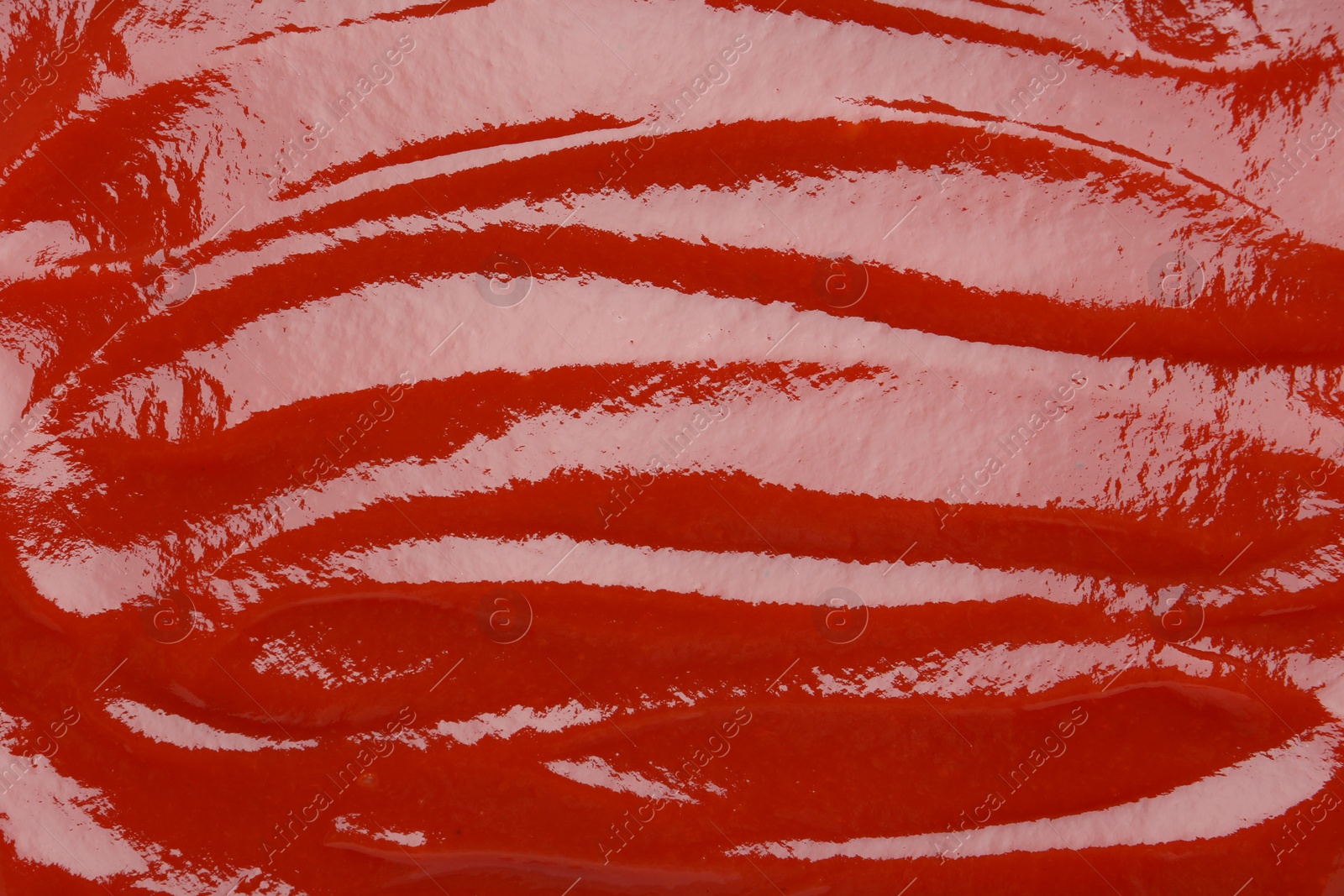 Photo of Tasty ketchup as background, top view. Tomato sauce