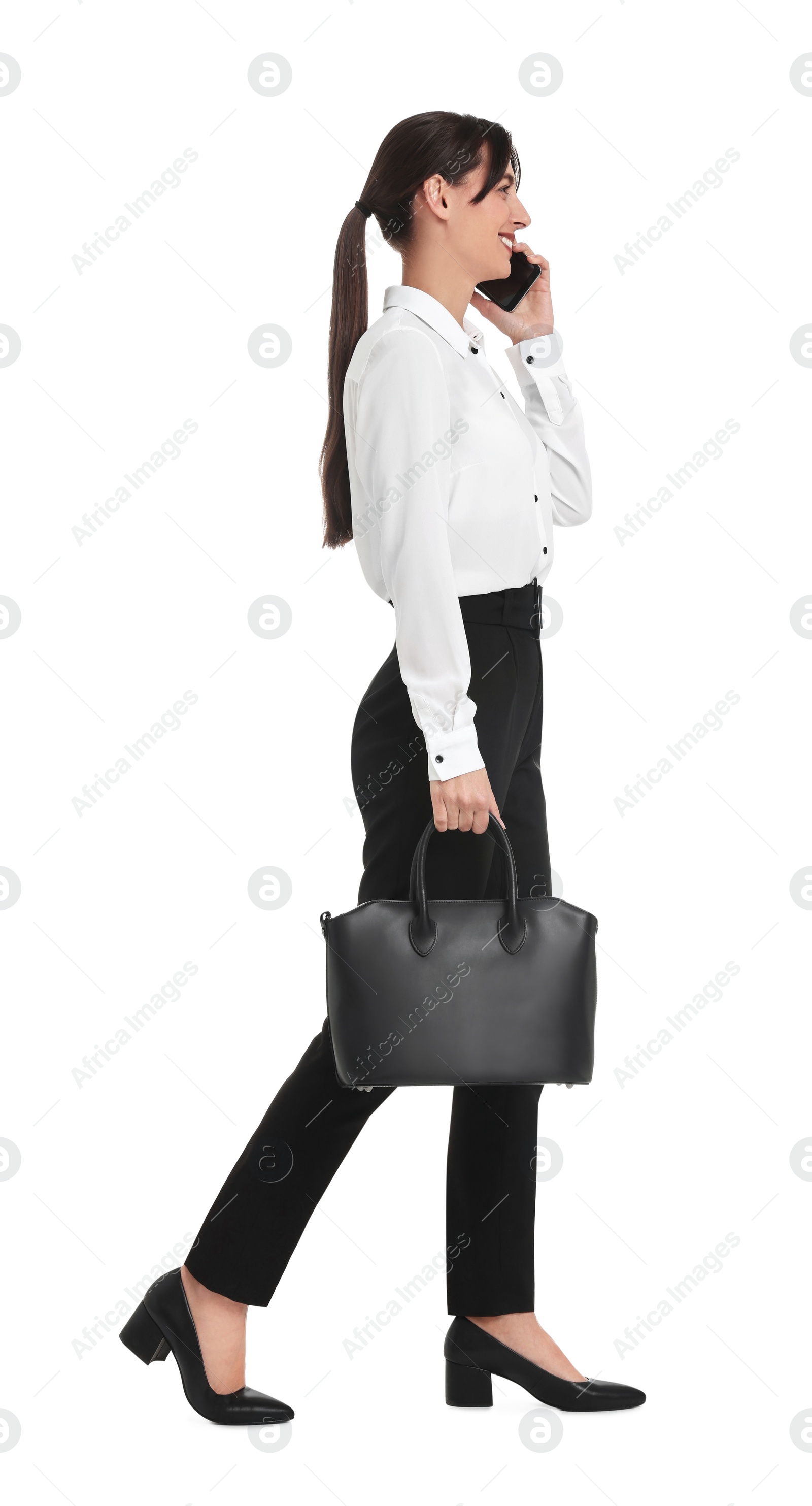 Photo of Happy businesswoman with bag talking on smartphone against white background