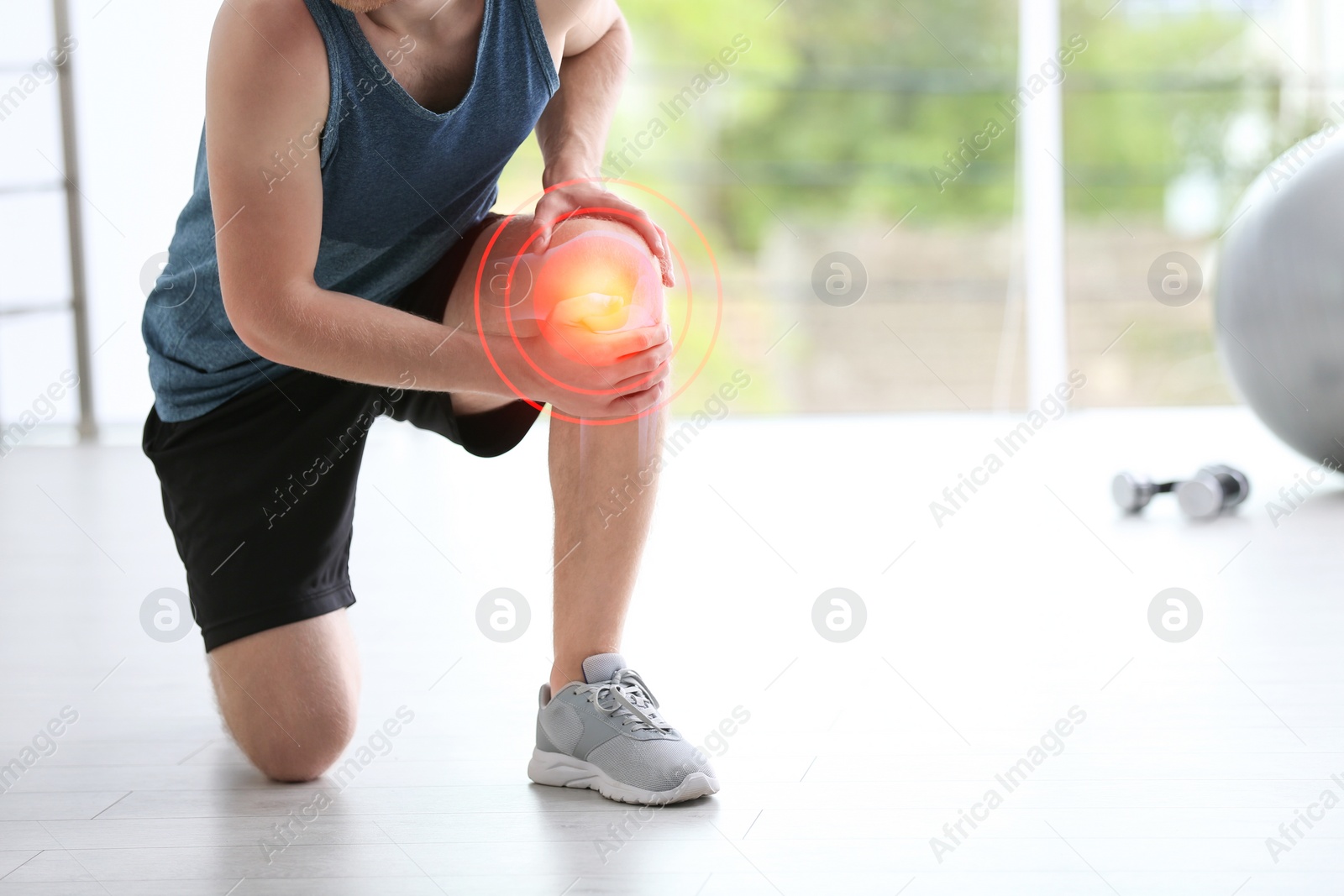 Image of Man in suffering from knee pain at gym, closeup