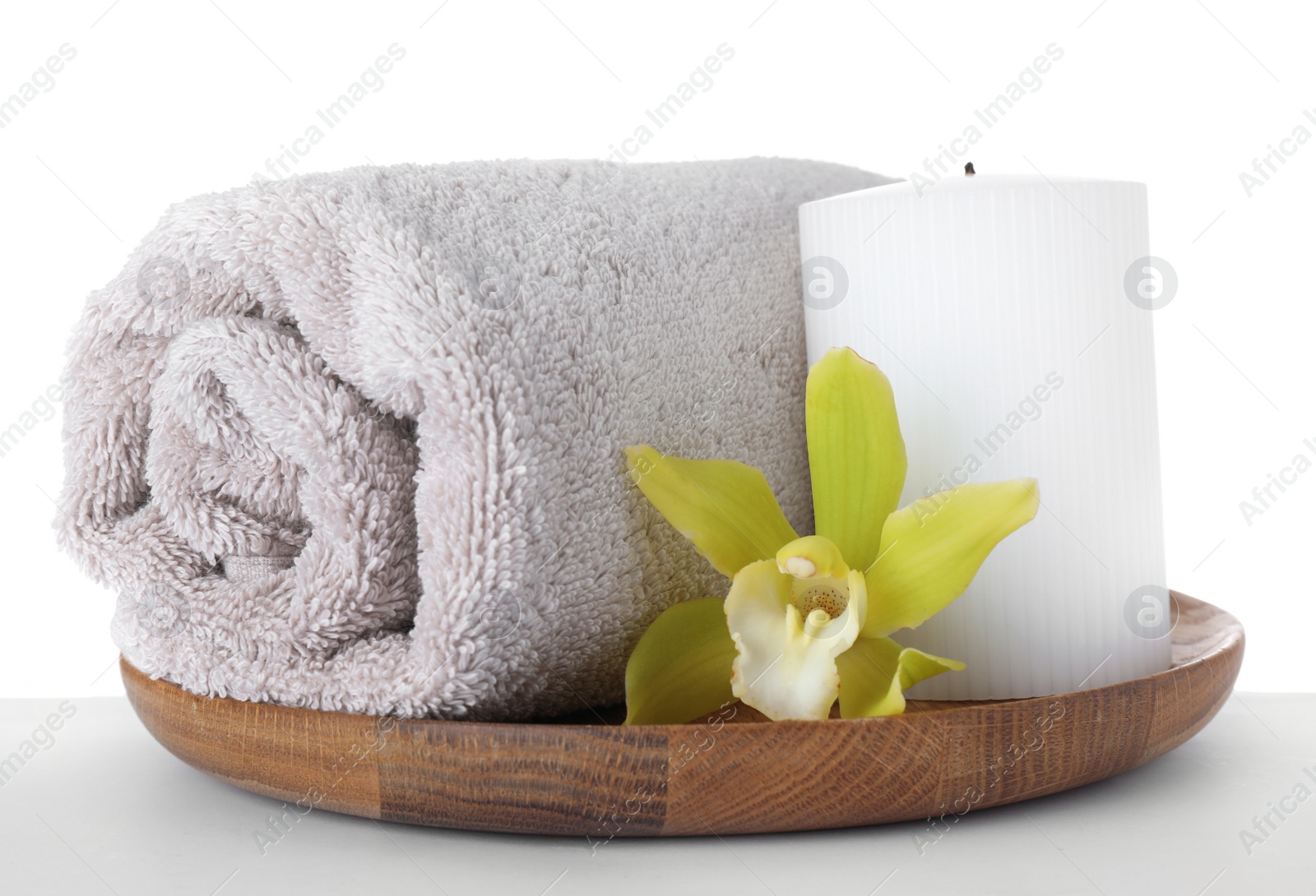 Photo of Wooden tray with towel, exotic flower and candle isolated on white