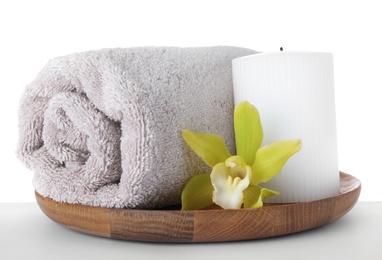 Photo of Wooden tray with towel, exotic flower and candle isolated on white