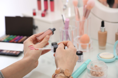 Photo of Woman applying makeup at dressing table, closeup