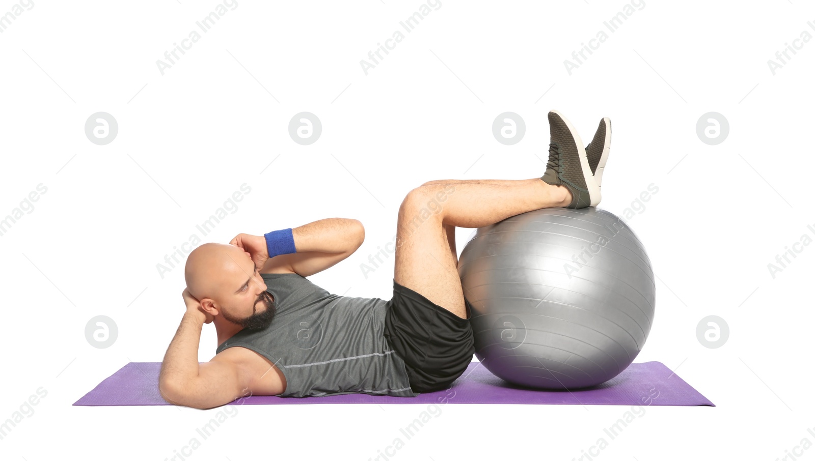 Photo of Overweight man doing exercise with fitness ball on white background