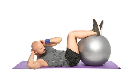 Photo of Overweight man doing exercise with fitness ball on white background