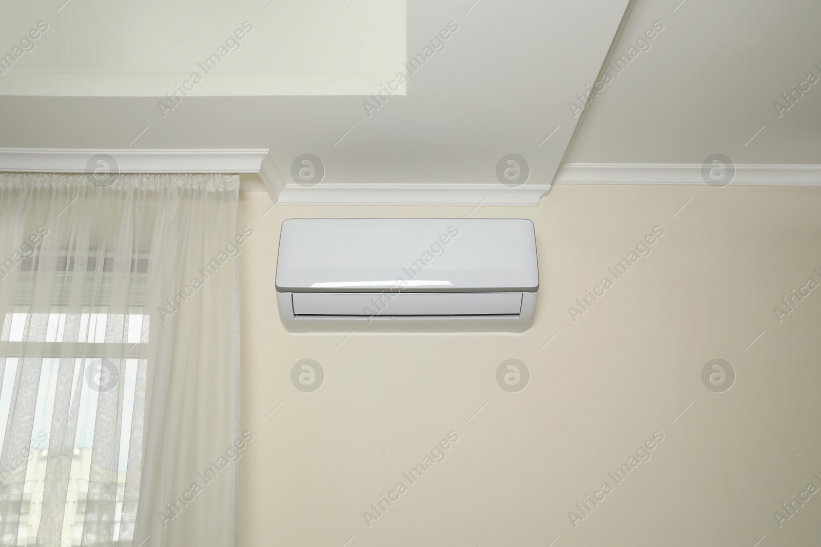 Photo of Modern air conditioner on white wall indoors