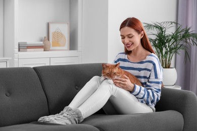 Photo of Happy woman with her cute cat on sofa at home