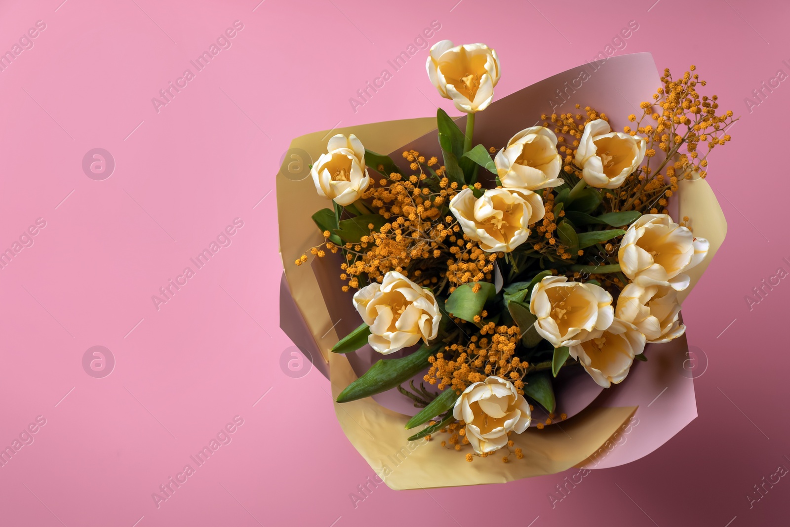 Photo of Bouquet with beautiful tulips and mimosa flowers on pink background, top view. Space for text