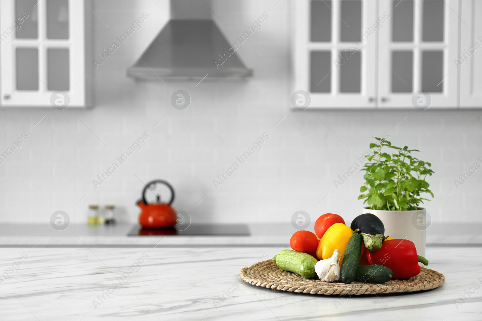 Photo of Different fresh vegetables on white table in modern kitchen. Space for text