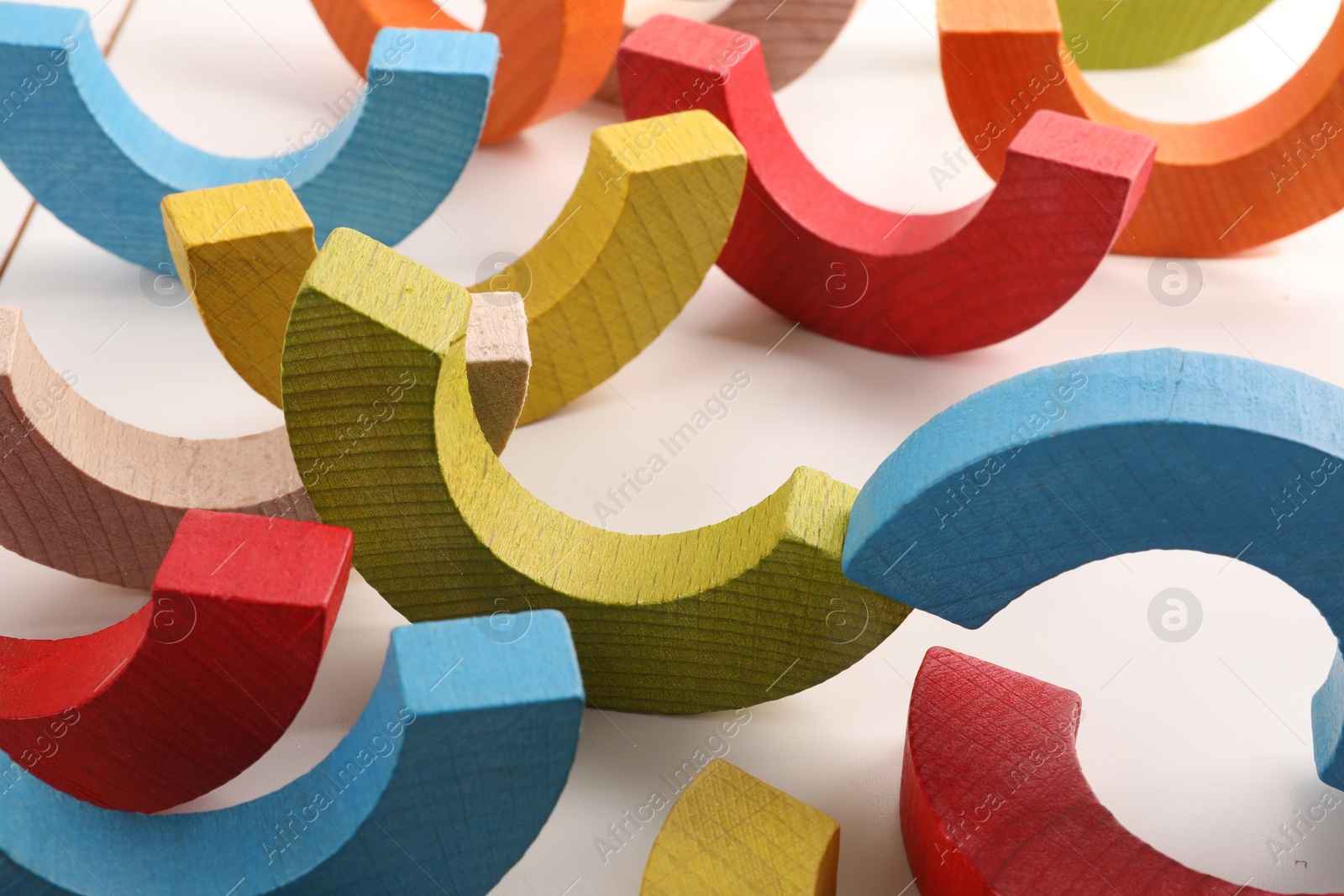 Photo of Colorful wooden pieces of playing set on white table, closeup. Educational toy for motor skills development