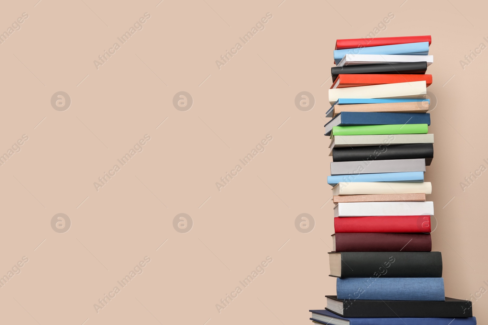 Photo of Stack of hardcover books on beige background. Space for text