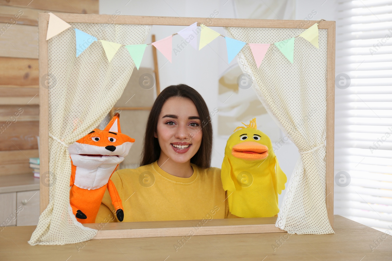 Photo of Young woman performing puppet show at home